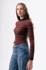Top de manga larga de tejido de punto con cuello redondo, estampado geométrico en tonos rojos y rosados.