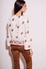 Blusa blanca con bordado de cachemir en negro, corte oversize y mangas acampanadas.