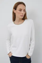 Remera de manga larga en color azul marino, confeccionada en tejido suave. Presenta un delicado detalle de bordado festoneado en color blanco tanto en el cuello redondo como en los puños, aportando un toque distintivo a esta prenda básica.