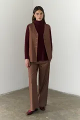 Chaleco azul con cuello en V y cierre frontal con botones marrones.