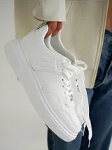 Championes blancos de estilo urbano, con suela de plataforma y cordones.