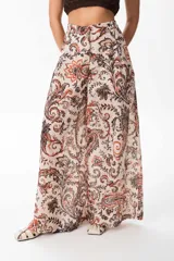 Pantalón de corte sastrero y pierna amplia, confeccionado en tela ligera de poliéster con textura tipo broderie y estampado paisley en tonos tierra.