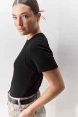 Remera blanca de manga corta y cuello redondo, con calce ajustado al cuerpo y diseño liso y minimalista.
