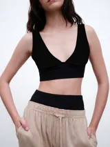 Top de bikini negro con escote en V profundo, confeccionado en tejido de poliamida y elastano con protección UV 50 y secado rápido.