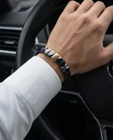 Pulsera elástica compuesta por eslabones de cerámica negra con acabado facetado y una pieza central rectangular con baño de oro.