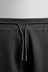 Pantalón jogger relaxed fit Zara Athleticz de tejido técnico compacto elástico con mezcla de algodón. Presenta cintura elástica ajustable con cordón, bolsillos laterales en la cadera, bolsillo trasero con cierre de cremallera, bajo ajustable con elástico y detalle de logo estampado en la pernera.