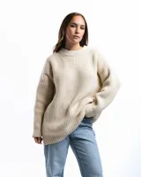 Sweater unisex color crema de lana merino, con cuello redondo y corte holgado.