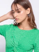 Top negro de manga corta con nudo en la parte delantera y textura diferenciada.