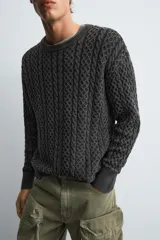 Jersey de corte relajado confeccionado en tejido de algodón con textura de trenzas. Presenta cuello redondo, manga larga y acabados en rib. Posee un efecto lavado que le otorga un aspecto único.