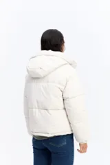 Campera puffer color crema con capucha, cuello alto, cierre frontal y puños elásticos.