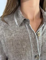 Vestido largo de lino color azul, con diseño estilo camisero, cuello camisero, cierre frontal con botones de madera y mangas largas con presilla para arremangar.