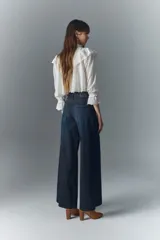 Jean de corte oxford tiro alto, color azul oscuro, con pierna que se ensancha desde la cadera hacia el ruedo. Confeccionado en denim confort con poco elastano, cierre y botón.