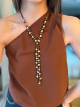 Collar estilo corbatín largo confeccionado con cuentas de nácar rojo, abalorios metalizados en tonos dorados y plateados, y mostacillas. Cuenta con cadena de acero y diseño colgante en forma de corbata.