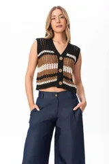 Chaleco tejido a crochet con rayas horizontales en negro, marrón y blanco. Tiene cuello en V y cierre frontal con botones de madera.