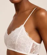 Soutien femenino modelo top de encaje floral blanco, sin copa, sin aro y con tirantes ajustables.