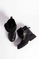 Borcegos de cuero vacuno en tonos marrón, con diseño de caña media y cuello con forro de piel sintética negra. Presentan cordones marrones, ganchos metálicos para ajuste y suela de goma tipo track con plataforma.