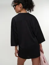 Remera deportiva de manga corta rosada, con escote en V y corte oversized de tejido dry fit.