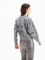 Buzo de algodón gris con estampa de abeja en el centro y diseño de flores oscuras dispersas por toda la prenda. Cuenta con cuello redondo, mangas largas y puños y cintura elastizados.