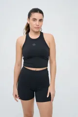 Top deportivo Umbro modelo Kia, de color negro, con cuello redondo y diseño ajustado. Presenta el logo de la marca estampado en el centro del pecho.