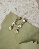 Aros colgantes de diseño orgánico con textura irregular, compuestos por tres piezas eslabonadas de metal con acabado brillante.