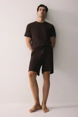 Conjunto de pijama de dos piezas color marrón oscuro, compuesto por una remera de manga corta con cuello redondo y un short con cintura elástica ajustable mediante cordón y bolsillos laterales.