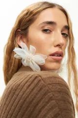 Aros colgantes con diseño de flor grande elaborada en tela tipo tul color blanco, con centro decorado con pequeñas cuentas brillantes. Cierre de gancho metálico.