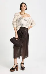 Sweater beige de punto calado con escote en V profundo, mangas largas holgadas con puños acanalados y detalle de lazo ajustable en el lateral.