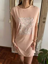 Remerón de algodón color salmón con estampa floral central en tonos suaves. Presenta cuello redondo y mangas cortas con diseño holgado.