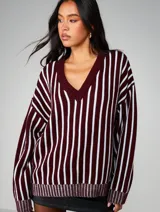 Sweater oversized de tejido de punto con diseño de rayas verticales en contraste, escote en V y mangas amplias con puños acanalados.