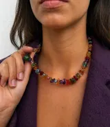 Collar corto compuesto por piedras naturales en forma de chips irregulares de diversos colores y transparencias, con cierre metálico bañado en oro 18k.
