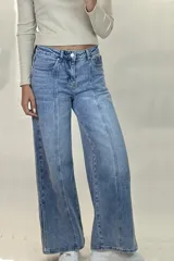 Pantalón de jean estilo wide leg con tiro alto, costuras verticales decorativas en el frente y corte diagonal en la parte inferior de las piernas.