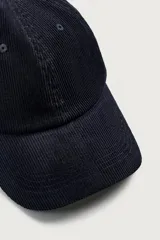 Gorra de seis paneles confeccionada en pana de algodón con visera curva y ajuste en la parte posterior.