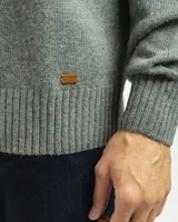 Buzo tejido de punto con cuello redondo, manga larga y puños y ruedo acanalados. Presenta un diseño clásico y versátil con un pequeño detalle de etiqueta en el lateral inferior.