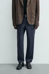 Pantalón chino de corte regular fit, confeccionado en tejido de algodón con elasticidad. Presenta bolsillos frontales, bolsillos traseros de vivo y cierre frontal con cremallera y botón.