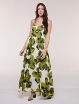Vestido maxi de fondo blanco con estampado de flores grandes en tonos verde y marrón, con escote en V, breteles finos y detalle de abertura cut-out en el centro del busto.