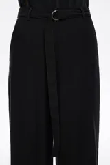 Pantalón negro de tiro alto con corte ancho y acampanado, confeccionado en tejido de viscosa y poliéster. Incluye cinturón de tela a juego con hebilla metálica en forma de "C" y puños doblados en los tobillos.