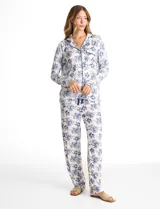 Conjunto de pijama de dos piezas con estampado animal print. La parte superior es una camisa de manga larga con cuello solapa, escote en V, cierre frontal con botones y bolsillo aplicado. El pantalón cuenta con cintura elástica y lazo de ajuste.