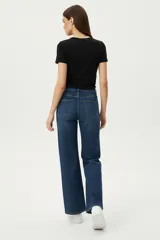 Pantalon de jean de corte ancho y tiro alto, con diseño de cinco bolsillos y cierre frontal con botón y cremallera.