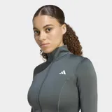 Campera deportiva entallada Adidas Optime Essentials color gris, con cuello alto, cierre frontal completo, mangas largas con aberturas para los pulgares y logo de la marca en blanco.