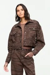 Chaqueta de denim de corte corto en tono marrón con estampado de cebra, cuello camisero, cierre frontal con botones metálicos y bolsillos delanteros con solapa.