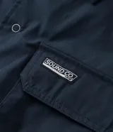 Camisa de manga corta color azul marino de corte boxy, con cuello inglés, cierre frontal de botones metálicos a presión y bolsillos cargo en el pecho.