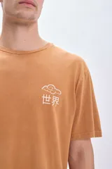 Remera color ocre de corte amplio con estampa en la espalda que incluye un plato de ramen, palillos y texto en inglés y japonés.