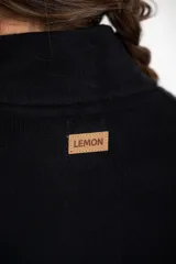 Cardigan negro de corte oversize, con cuello alto, cierre frontal de botones y mangas tres cuartos. Presenta un diseño holgado con bolsillos frontales y una caída fluida.