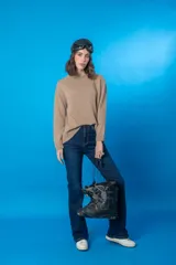 Sweater color beige de tejido de punto con cuello redondo y mangas largas.