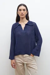 Sweater de punto calado en color azul, con cuello polo y escote en V. Presenta mangas largas con puños rectos y un diseño de tejido vertical.