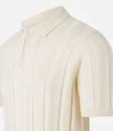 Camisa de punto color marrón con textura acanalada y perforaciones. Presenta cuello polo con cierre de cremallera frontal y mangas cortas.