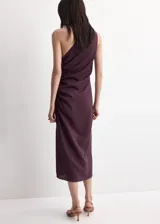 Vestido midi color marrón, de diseño asimétrico con un solo hombro descubierto, detalle fruncido en el lateral y abertura en el bajo.
