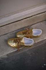 Championes negros de cuero con apliques metálicos plateados y suela color caramelo.