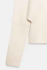 Jersey de punto color verde lima, con cuello pico y manga larga de sisa ancha que se estrecha hacia la muñeca.