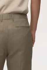 Pantalón de traje de lino color tostado, corte slim fit con piernas de corte recto, pinzas marcadas y trabillas para cinturón.